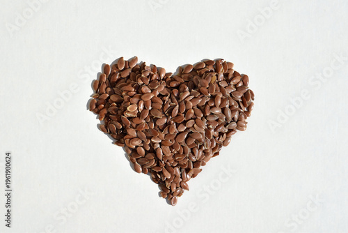 Brown flax seeds on a white background, flax seed heart