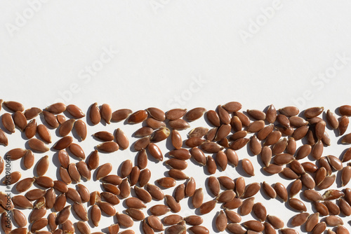 Brown flax seeds on a white background, copy space for text