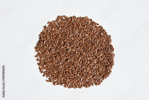 Brown flax seeds on a white background