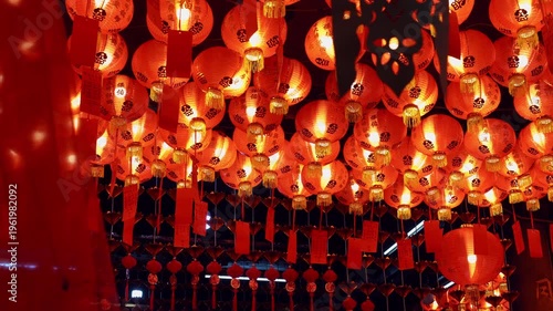 Cinematic View of Glowing Red Lanterns Swaying in a Chinese Shrine During Lunar New Year Celebration in Thailand with Soft Foreground Bokeh