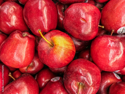 close-up shot of a pile of fresh red apples. The vibrant skins show natural highlights and speckles, emphasizing a healthy, harvest-ready appearance for food and wellness content.