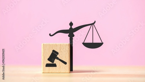 Symbolic Illustration of Justice and Law Featuring a Gavel on a Wooden Block Beside a Black Silhouette of Scales of Justice Against a Soft Pink Backdrop and Light Wood Surface