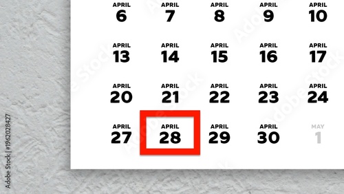 Close-up of the date April 28th marked with a red cursor on the wall calendar 2026