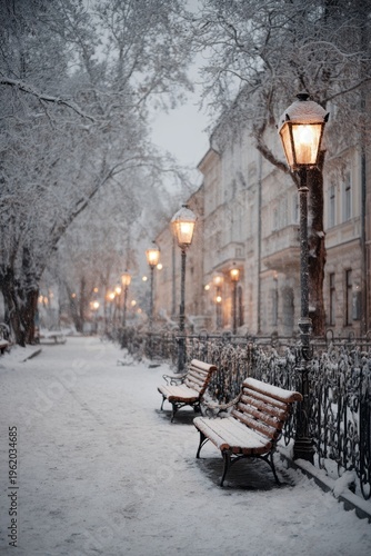 Snow covering park benches, trees, and path with illuminated lampposts on a cold winter evening