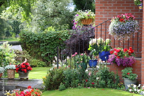 Εκτύπωση καμβά Colourful pots, hanging baskets and flower beds in a garden in summer