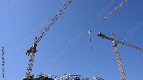 Yellow Tower Cranes Working on High-Rise Building Construction