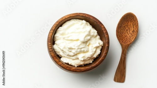 Creamy Cottage Cheese in Wooden Bowl: A close-up, high-angle shot presents a delightful wooden bowl filled with luscious, creamy cottage cheese, accompanied by a wooden spoon ready for serving.