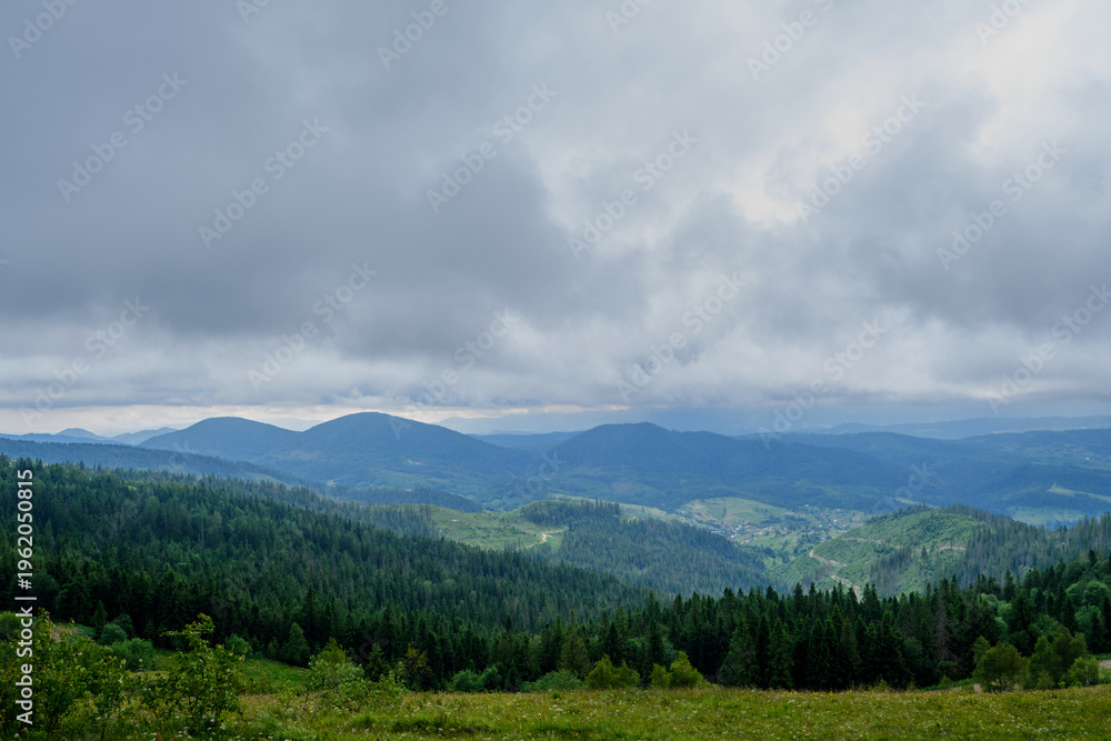 Fototapeta premium Panoramic Mountain Landscape with Dense Forests and Cloudy Sky