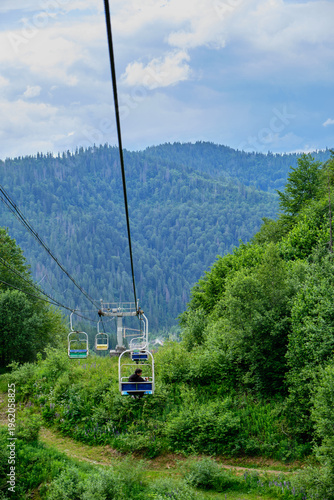 Man and Dog Riding Chairlift in Mountains