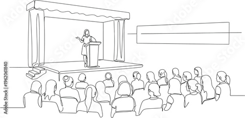 man on stage speaking to attentive audience