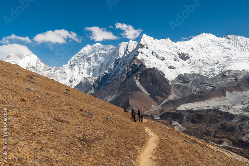Three Passes Trek Nepal Himalayas hikers on mountain trail with snow peaks Everest region adventure travel