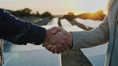 Two entrepreneurs sign a deal against a backdrop of solar panels in the sunset, reflecting their collaboration on clean energy, sustainability, and environmental concerns.