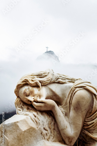 Fotografija Sculpture of a woman reclining on a stone, with a serene and melancholic expression, at the feet of Christ