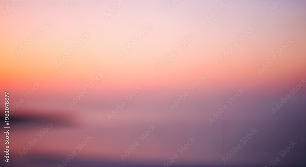 Fototapeta premium Blurry sunset over water with a colorful sky and silhouette of land