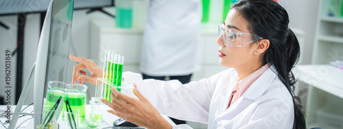 Scientist compare experimental data and analyzing green solution in a modern laboratory, discovering sustainable innovations for climate action, net zero goals, and eco-friendly technology development