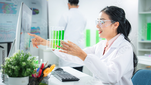 Scientist compare experimental data and analyzing green solution in a modern laboratory, discovering sustainable innovations for climate action, net zero goals, and eco-friendly technology development