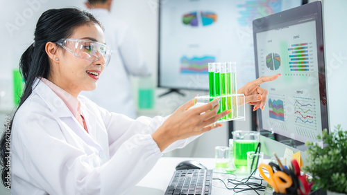 Scientist compare experimental data and analyzing green solution in a modern laboratory, discovering sustainable innovations for climate action, net zero goals, and eco-friendly technology development