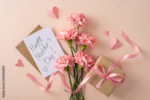 Handwritten Happy Mother's Day card with pink carnations, kraft gift box tied with ribbon and paper hearts on a soft pastel background evoking love, tenderness, celebration and feminine charm