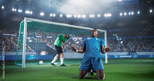 Quadro em tela Black Male Soccer Striker Drops to His Knees in Front of the Net After Scoring in a Major International Championship Match, While the Goalkeeper Turns Away Inside a Packed World Football Stadium