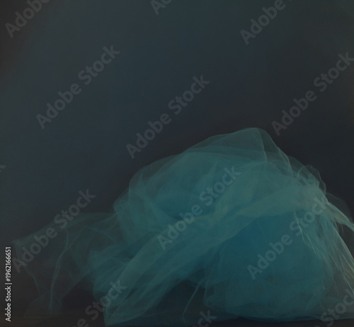 Soft blue tulle blur motion on dark background. Abstract airy cyan smoke mist fluidity overlay.