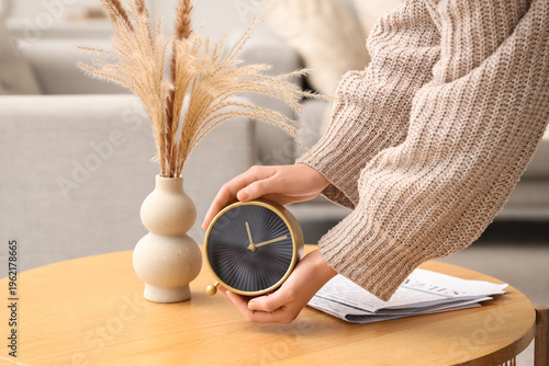 Woman putting alarm clock o...