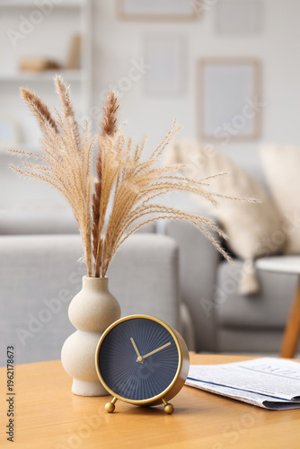 Alarm clock and vase on tab...