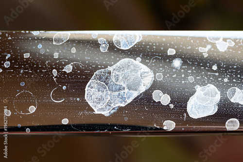 Foto Close up of white dried limescale and water spots on a shiny chrome bathroom or