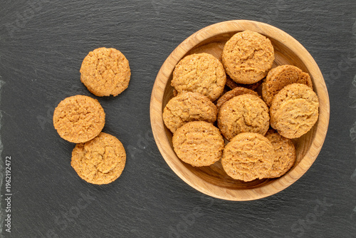 Oatmeal cookies with kitchen utensils on slate stone, close-up. Top view.