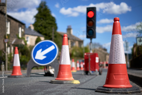 Photos A red signal on a traffic light behind a series of road cones marking out roadwo
