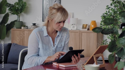 Focused businesswoman working from home on tablet