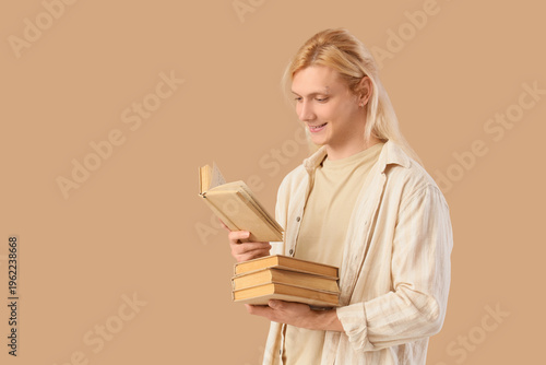 Young blonde man with books...