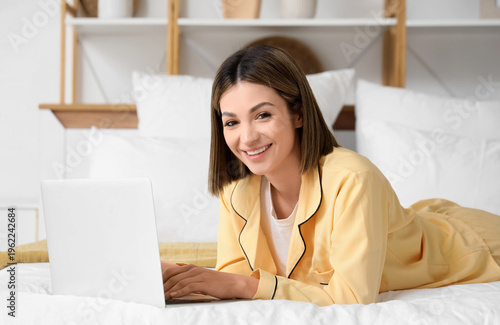 Young woman using laptop to...