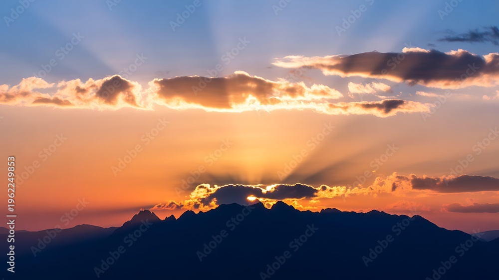 Obraz premium Sunset over a mountain range with clouds and sun rays