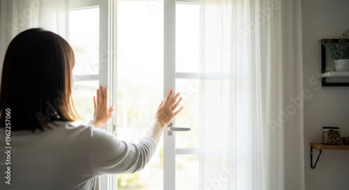 This is a woman opening a window to ventilate the room.