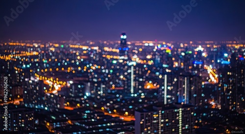A blurry nighttime cityscape with numerous illuminated skyscrapers and streets