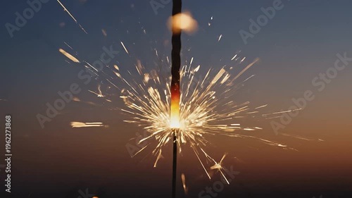 A vibrant sparkler ignites, releasing a burst of colorful sparks against a twilight sky, showcasing the excitement and joy of a festive celebration, with smoke trailing from the glowing tip