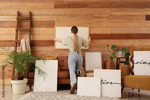 Young woman hanging blank f...