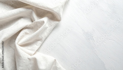  Tela clara con pliegues naturales sobre fondo blanco, creando una composición suave y minimalista.
