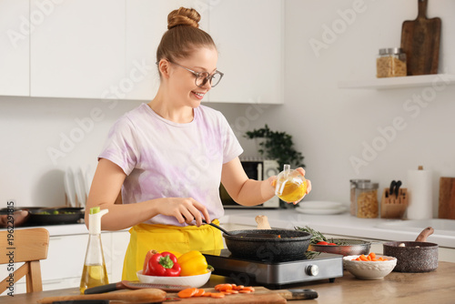 Young woman pouring oil int...