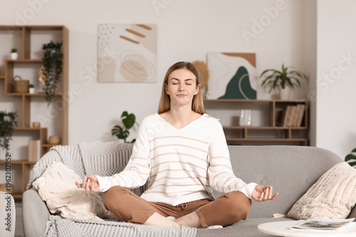 Young woman meditating on s...