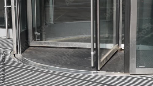 business center in big city, central entrance with revolving door, people come in and go out, modern architecture, urban background