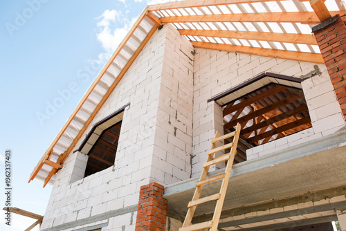 Angular perspective of house at lag laying stage, use of aerated block and modern timber, stepwise roof stropil assembly.
