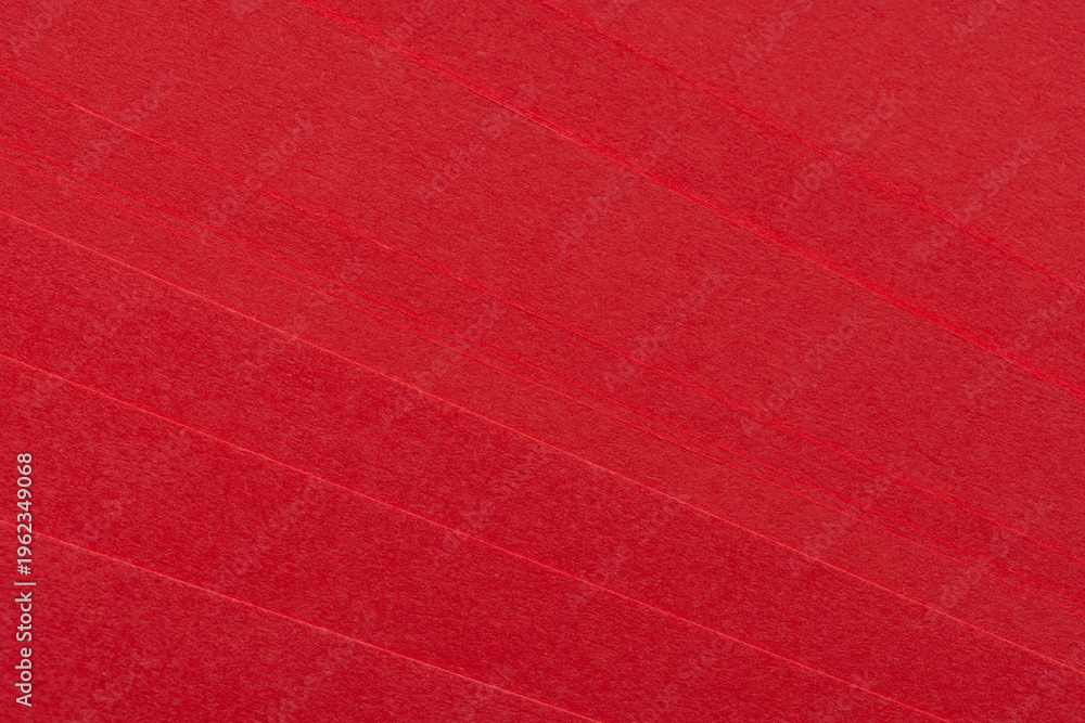 Fototapeta premium Close-up of Vibrant Red Paper Texture with Layered Edges,A high-resolution close-up shot of stacked red craft paper, showcasing a rich fibrous texture and subtle diagonal lines from the paper edges.
