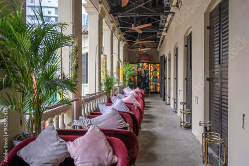 Hong Kong, China. Stylish corridor seating at Tai Kwun heritage complex with colonial architecture, tropical plants and vibrant interior design in Central