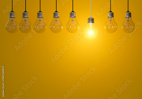 Seven clear light bulbs hanging from cords on yellow background one glowing brightly