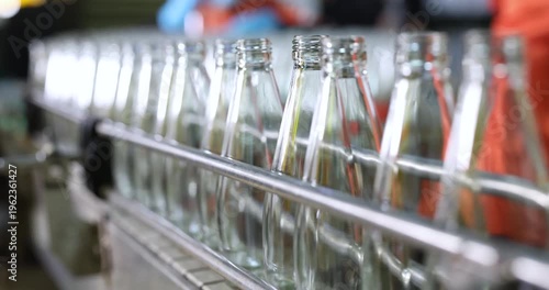 Empthy bottles on a conveyor belt in bottling process at a factory	
