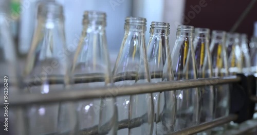 Empthy bottles on a conveyor belt in bottling process at a factory	

