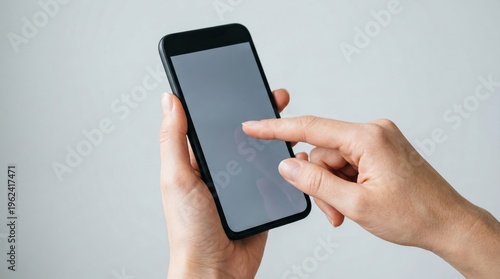 Finger touching smartphone screen on gray background