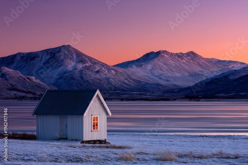 Winter twilight over a cozy cabin by a mountain lake