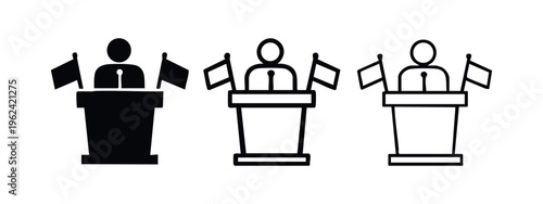 Speaker at a podium with microphone and flags, representing public address